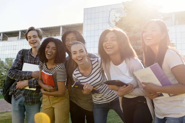 Multi-etnische groep van jonge vrolijke studenten permanent buitenshuis — Stockfoto