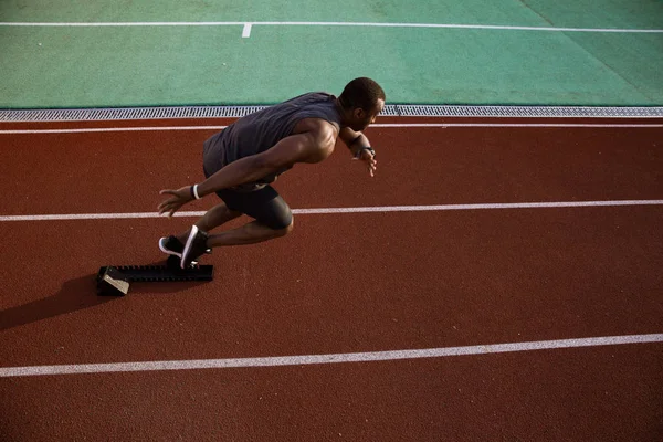 Vista lateral de un deportista afro-americano que comienza la carrera — Foto de Stock