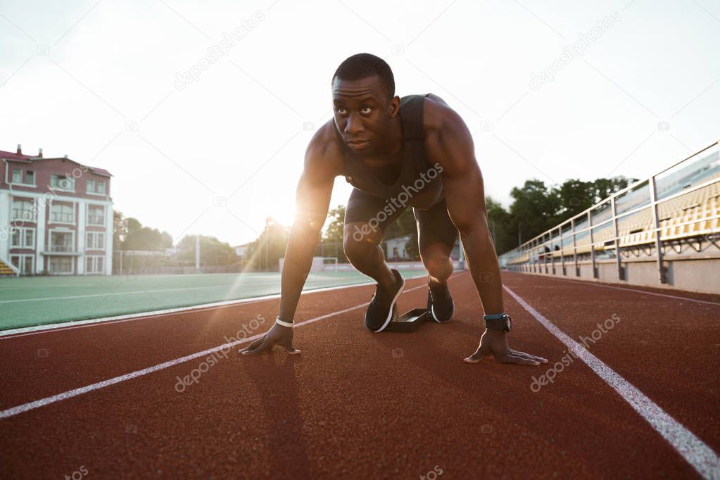 Fit confident african sportsman standing in starting position