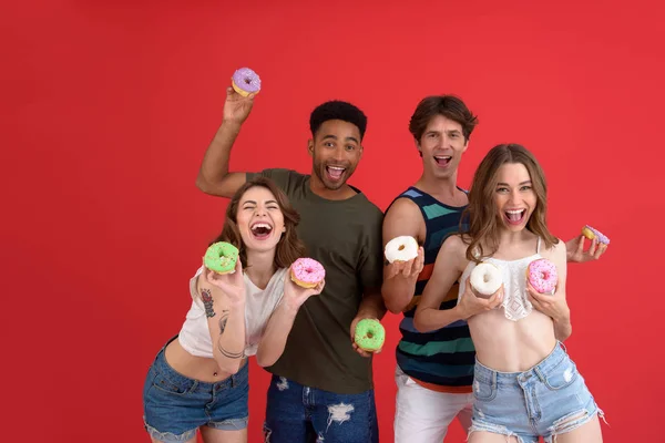 Lächelnde Freunde, die mit Donuts stehen — Stockfoto