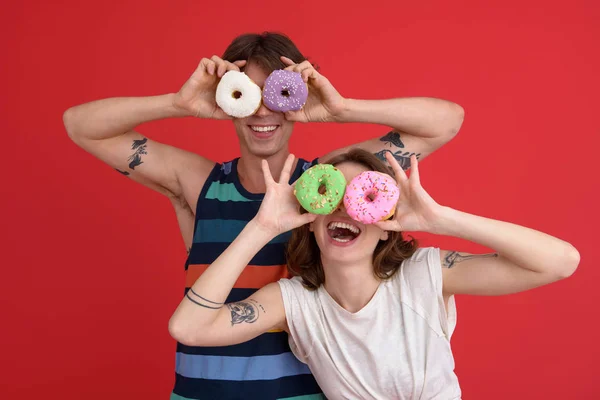 Молодые веселые два друга стоят с пончиками — стоковое фото