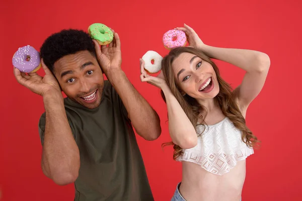 Счастливые два друга стоят с пончиками — стоковое фото