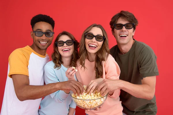 Gelukkig groep vrienden kijken naar film eten popcorn. — Stockfoto