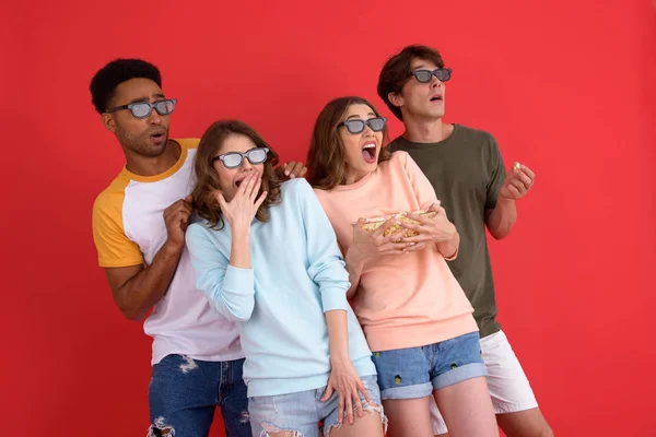 Шокированная группа друзей, смотрящих фильм, поедающих попкорн . — стоковое фото