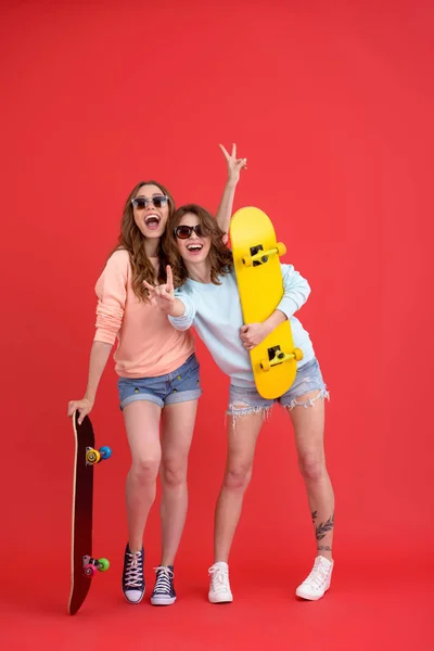 Счастливы две подруги, держащие в руках скейтборды . — стоковое фото