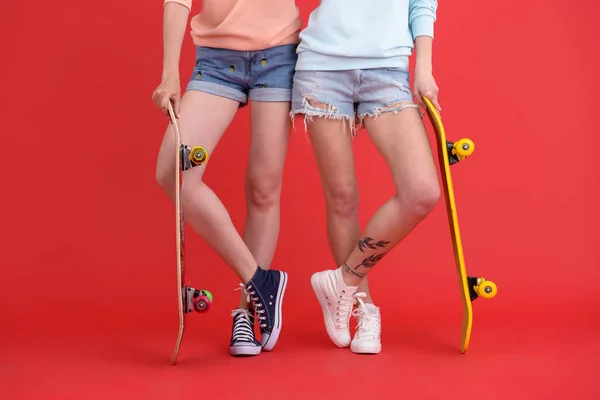 Cropped image of young two ladies holding skateboards. — Stock Photo, Image