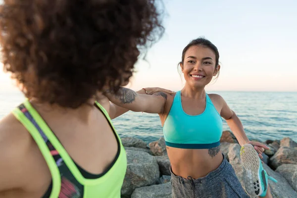 Dos sonrientes jóvenes fitness mujeres calentando — Foto de Stock