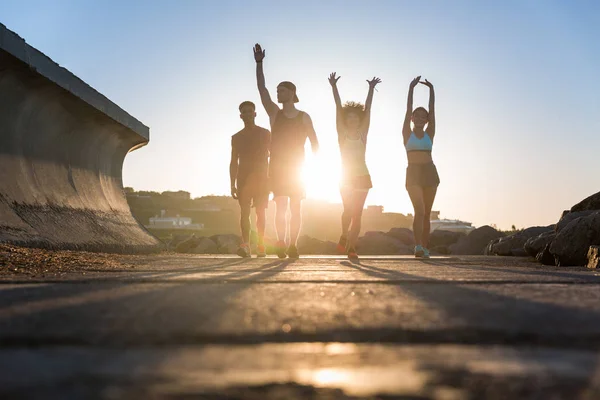 Gruppe von Läufern beim Training auf einer Straße am Meer — Stockfoto