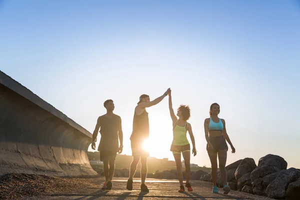 Grupp av löpare som tränar på en väg vid havet — Stockfoto