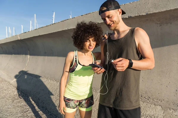 Leende unga fitness par lyssnar på musik — Stockfoto