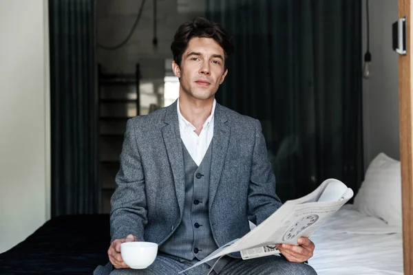 Businessman with coffee cup reading newspaper — Stock Photo, Image