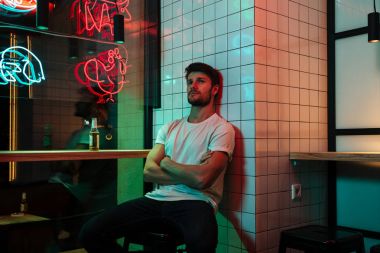 Bir kenara arayan kahvede oturan genç yakışıklı adam.