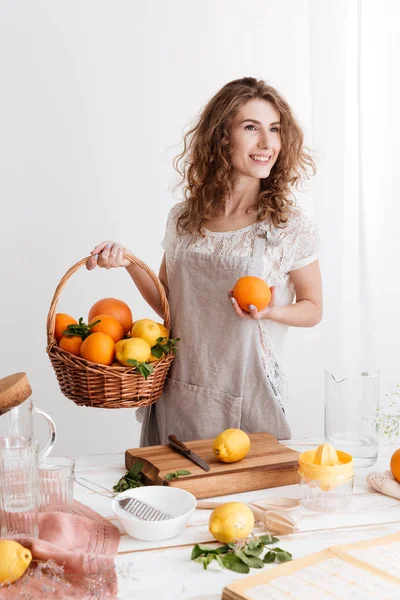 Genç kadın portakal sepetle holding ayakta