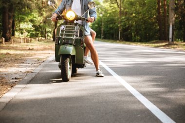 Genç çekici sevgi dolu çift scooter üzerinde fotoğraf kırpılmış