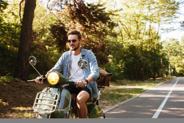 Schwerer junger bärtiger Mann auf Motorroller im Freien. — Stockfoto