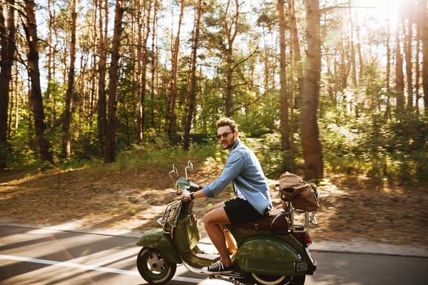 Sakallı adam açık havada scooter üzerinde. Bir kenara arıyorsunuz.