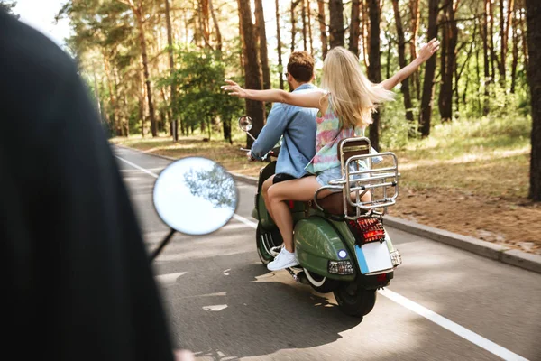 Liebespaar auf Motorroller mit Freundin im Freien — Stockfoto