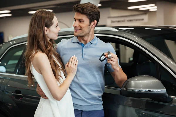Mujer de pie cerca de coche con novio en concesionario de coches —  Fotos de Stock