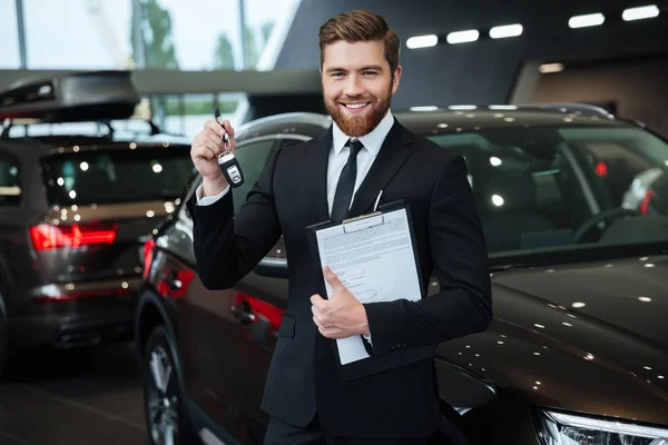 Stilig ung bilförsäljare som står vid generalagenten — Stockfoto