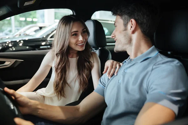 Junges Paar sitzt in neuem Auto — Stockfoto