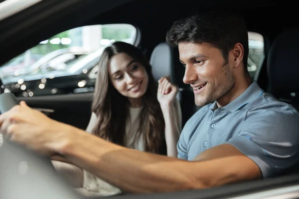 Couple sitting at the front seats of their new car — Stock Photo, Image