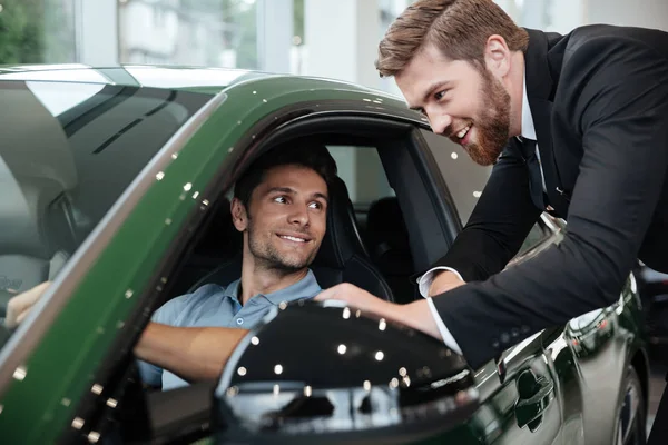 Comerciante masculino profissional que vende carro a um cliente — Fotografia de Stock