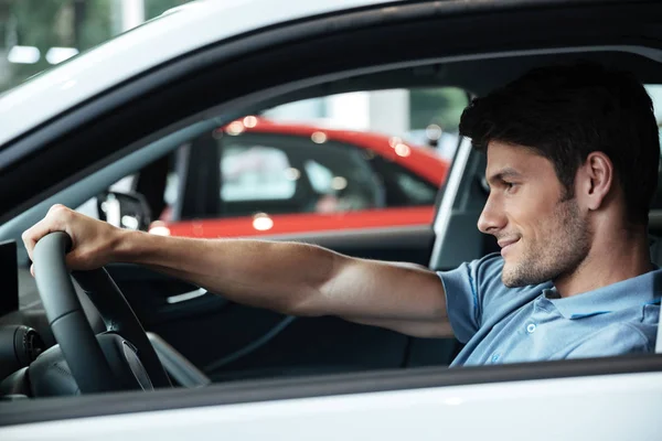 Glücklich lächelnder männlicher Kunde testet sein neues Auto — Stockfoto