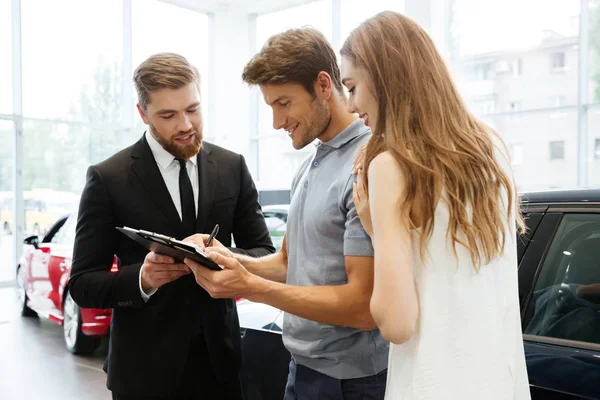 Guapo vendedor de documentos de presentación con sus clientes felices — Foto de Stock