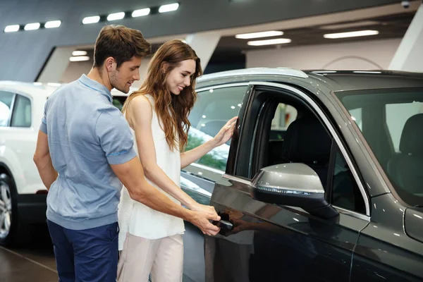 Couple looking for a new car at the dealership showroom Stock Image