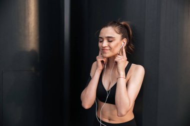 Mutlu genç spor Bayan Earphones ile ayakta