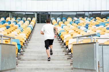 Arkadan yukarı koşan bir genç adam görünüşü