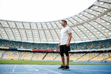 Tam uzunlukta bir yarış pisti üzerinde duran genç sporcu