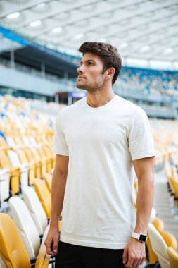 Spor Stadı'nda açık havada duran ve bir kenara arayan adam.