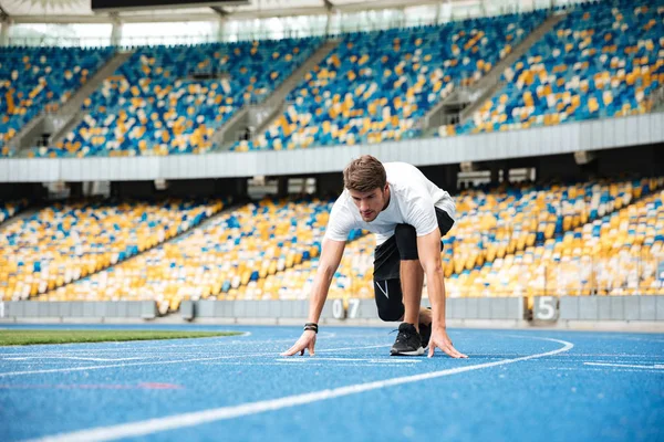 Jonge mannelijke atleet om te beginnen met een race — Stockfoto