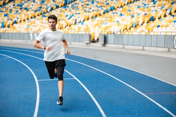 Atleta homem correndo em uma pista de corrida — Fotografia de Stock