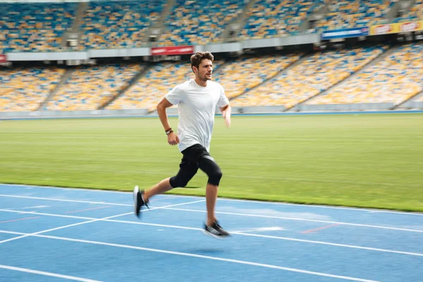 Seitenansicht eines jungen Profi-Sprinters beim Laufen — Stockfoto