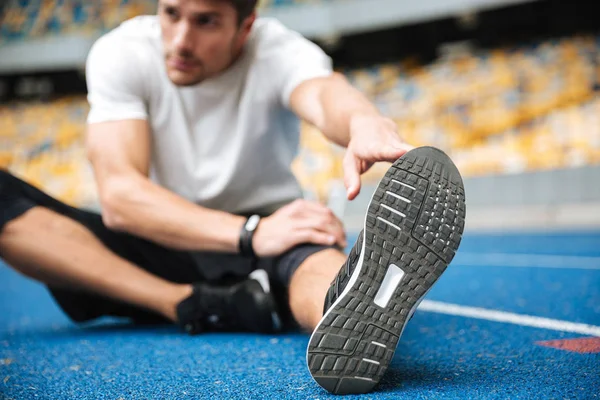 Tinerii sportivi de pe stadion fac exerciții de întindere . — Fotografie, imagine de stoc