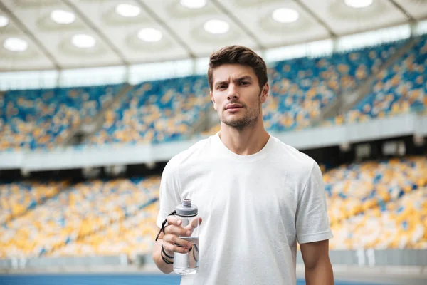 Joven atleta masculino sosteniendo botella de agua — Foto de Stock