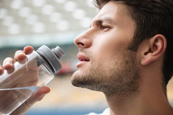 Nahaufnahme Porträt eines gutaussehenden Mannes, der Wasser trinkt — Stockfoto