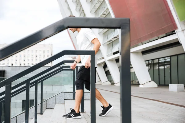 Homem de esportes em pé na escada no estádio — Fotografia de Stock
