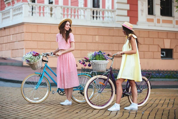 Девушки стоят на улице с велосипедами — стоковое фото