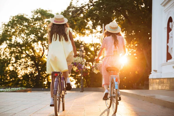 İki genç bayanlar Bisiklet görüntüsünü arkadan görünüm.