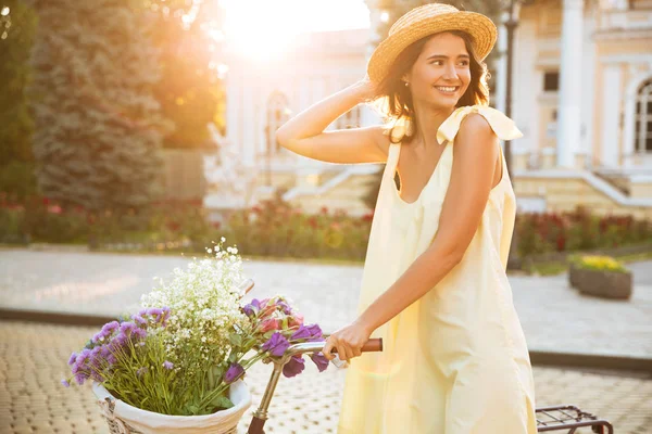 Vintage bisiklet üzerinde oturan şapkalı mutlu gülümseyen kız