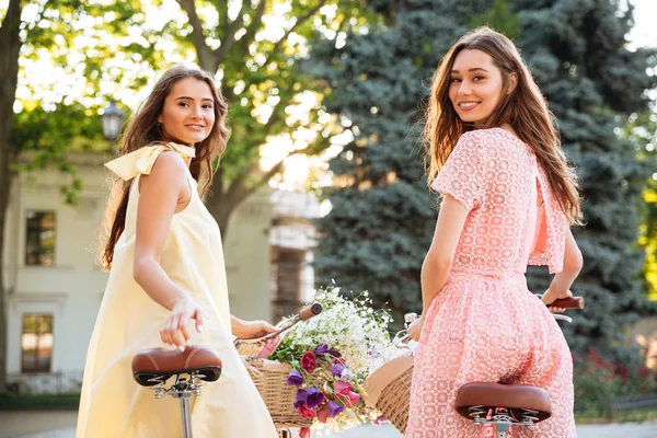 Retro bisiklet üzerinde oturan iki genç ve güzel kadın