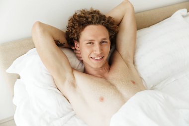 Mutlu bir adam evde yatakta yatıyor