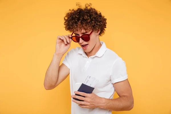 Joven juguetón guiñando un ojo y mirando por encima de las gafas — Foto de Stock