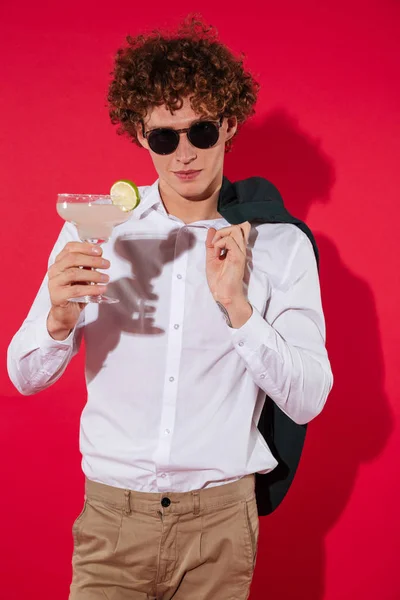 Handsome stylish man in white shirt and jacket holding cocktail