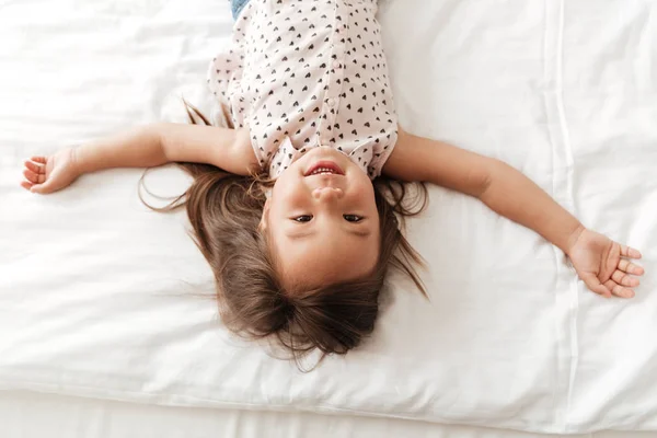 Милая маленькая милая азиатка в доме лежит на кровати — стоковое фото
