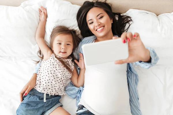 Lachende Aziatische vrouw selfie met haar dochtertje — Stockfoto