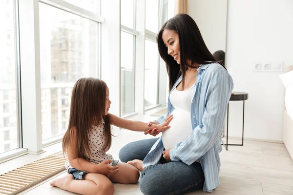 Feliz joven embarazada con hija pequeña — Foto de Stock